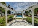 Tranquil backyard featuring a pool, pergola and garden with lush greenery, and decorative statues at 820 Druid S Rd, Clearwater, FL 33756