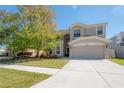 Two-story home boasts a two-car garage, well-maintained lawn, and welcoming curb appeal at 9224 Lost Mill Dr, Land O Lakes, FL 34638