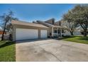 View of a three-car garage and front porch at 1028 Rosetree Ln, Tarpon Springs, FL 34689