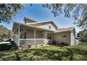 Exterior side view featuring the home's architecture, porch, and manicured lawn at 1028 Rosetree Ln, Tarpon Springs, FL 34689