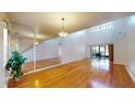 Bright living room with hardwood floors, high ceilings, and large mirror feature wall at 10488 Saint Tropez Pl, Tampa, FL 33615