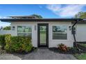 Close up front exterior of the house with black trim, white walls, and landscaped garden at 1054 W Baffin Dr, Venice, FL 34293