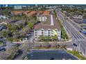 Exterior view of a condo building with palm trees, a parking lot and a view of the surrounding neighborhood at 1216 S Missouri Ave # 225, Clearwater, FL 33756