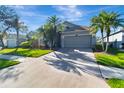 Inviting single-story home with a wide driveway, lush lawn, and mature landscaping at 1453 Appleton Pl, Wesley Chapel, FL 33543