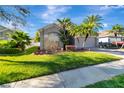 Well-maintained home featuring a green lawn, mature landscaping, and an inviting facade at 1453 Appleton Pl, Wesley Chapel, FL 33543