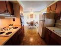 Cozy kitchen view that leads to a dining area with a ceiling fan and classic appliances at 1620 Dander Dr, Holiday, FL 34690