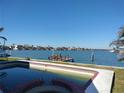 Relaxing backyard pool overlooking a scenic waterfront and dock at 16217 Redington Dr, Redington Beach, FL 33708