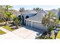 Charming single-story home featuring a three-car garage, arched entryway, and lush landscaping at 20824 Cedar Bluff Pl, Land O Lakes, FL 34638