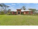 Charming single-story home featuring a well-manicured lawn and vibrant landscaping, complemented by a unique metal roof at 2307 7Th Sw St, Ruskin, FL 33570