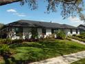 Well maintained house with a dark roof, solar panels, lush lawn, and mature trees at 2709 Fairway View Dr, Valrico, FL 33596