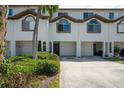 Townhouse exterior features garages, arched windows, and lush landscaping for added curb appeal at 325 Madeira Cir, Tierra Verde, FL 33715