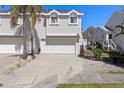 Inviting townhome featuring a well-kept front yard, a two-car garage, and classic architectural details at 525 Oceanview Ave, Palm Harbor, FL 34683