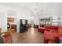 Bright and airy living room with high ceilings, wood floors, and a comfortable red sectional at 525 Oceanview Ave, Palm Harbor, FL 34683