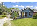 Charming blue bungalow with yellow front door and detached shed at 5915 N Otis Ave, Tampa, FL 33604