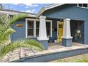 A closer view of the front porch with its striking yellow door and decorative plants at 5915 N Otis Ave, Tampa, FL 33604