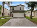 Charming two-story home featuring a well-maintained lawn, a two-car garage, and nice landscaping at 7842 Carriage Pointe Dr, Gibsonton, FL 33534