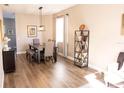 Bright dining area with wood flooring, a modern light fixture, and a dining table set for a meal at 8556 Tidal Bay Ln, Tampa, FL 33635