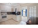 Efficient kitchen with white cabinets, tile backsplash, and a view to Florida Room at 8792 93Rd St, Seminole, FL 33777
