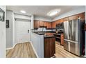 Modern kitchen with stainless steel appliances, dark countertops, and wood cabinets at 9481 Highland Oak Dr # 404, Tampa, FL 33647