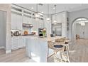 Bright kitchen featuring a large island, stainless steel appliances, pendant lighting, and ample white cabinetry at 809 Seascape Pl, Sarasota, FL 34240