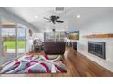 Spacious living room features a fireplace, ceiling fan, and sliding doors to outdoor space at 11980 Valencia Ct, Seminole, FL 33772