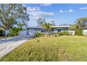Well-maintained home featuring a lush green lawn, meticulously landscaped garden, and a paved driveway leading to a garage at 1269 80Th N Ave, St Petersburg, FL 33702