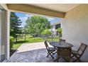 Relaxing outdoor patio with a table and chairs overlooking a fenced backyard and pond at 14542 Mirabelle Vista Cir, Tampa, FL 33626