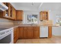Well-maintained kitchen with wood cabinets, tile backsplash, and functional appliances at 1549 San Christopher Dr, Dunedin, FL 34698