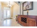 Elegant foyer with marble floors, chandelier, and a decorative wood console table with wine rack at 19140 Sunset Bay Dr, Land O Lakes, FL 34638