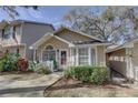 Inviting tan single-story home with a white picket fence, lush landscaping, and a welcoming walkway to the front entrance at 2312 Tallyho Ln, Palm Harbor, FL 34683