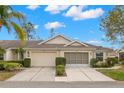 Charming home with a well-manicured lawn, beautiful landscaping, and attached garages at 2469 Nantucket Harbor Loop # 123, Sun City Center, FL 33573