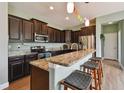 A stylish kitchen with dark wood cabinets, granite countertops, and stainless steel appliances at 501 Washita Stone Dr, Ruskin, FL 33570