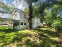 View of the side and backyard of the home, showcasing the lawn and surrounding trees at 5121 40Th N Ave, St Petersburg, FL 33709