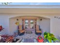 Inviting front entryway with double doors, decorative plants, and rocking chairs under a covered porch area at 6324 Balboa Ln, Apollo Beach, FL 33572