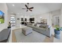 Open floor plan with living room, dining area, and kitchen with dark cabinets and island at 7133 Hatpin Loop, Wesley Chapel, FL 33545