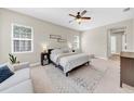 Bright bedroom featuring a ceiling fan, carpet floors, and two windows bringing in lots of light at 7133 Hatpin Loop, Wesley Chapel, FL 33545