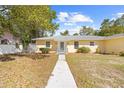 A welcoming single-story yellow house with a tidy front yard and a clean, concrete walkway to the entrance at 7183 Fireside St, Spring Hill, FL 34606