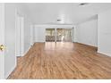 Spacious living room featuring wood-look floors and sliding glass doors that lead to a screened in patio at 7183 Fireside St, Spring Hill, FL 34606