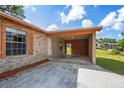 Exterior view of the home's carport featuring a stone facade and a view of the backyard at 801 Chess Pl, Seffner, FL 33584
