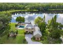 Breathtaking aerial view of estate home with pool, lake frontage, and mature trees at 8711 Brooke Angela Dr, Odessa, FL 33556