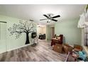 View of living room with light-green walls, vinyl plank flooring and fireplace decorated with a tree decal at 9048 94Th St, Seminole, FL 33777
