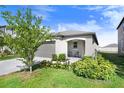 Charming single-story home featuring a well-manicured lawn, attached garage, and cozy front porch with seating at 9412 Lemon Drop Loop, Ruskin, FL 33573