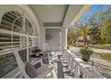 Charming front porch with white rocking chairs and decorative landscaping for a welcoming curb appeal at 9826 Laurel Ledge Dr, Riverview, FL 33569