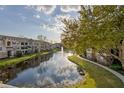 Scenic view of the condominium community with a tranquil lake and fountain at 10201 Courtney Palms Blvd # 204, Tampa, FL 33619