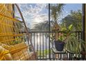 Relaxing patio with hanging chair overlooking the serene lake and lush palm trees at 10201 Courtney Palms Blvd # 204, Tampa, FL 33619