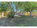 Expansive backyard with mature trees, a well-maintained lawn, and a wooden privacy fence at 10323 107Th N Ave, Largo, FL 33773