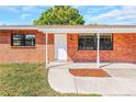 Close-up view of a brick home's entrance with white door and a small covered porch at 10323 107Th N Ave, Largo, FL 33773