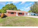 Cozy brick home with a covered carport and a spacious driveway on a sunny day at 10323 107Th N Ave, Largo, FL 33773