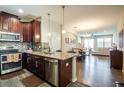 Modern kitchen with wood cabinets, stainless steel appliances, granite countertops, and decorative backsplash at 11648 Crowned Sparrow Ln, Tampa, FL 33626