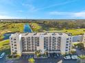 Elegant condo building overlooking a scenic golf course and pond, with well-maintained landscaping and ample parking at 1200 Country Club Dr # 2206, Largo, FL 33771